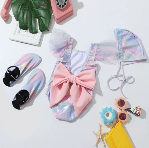 Baby accessories including pink bows, shoes, and pastel-colored decorative items.