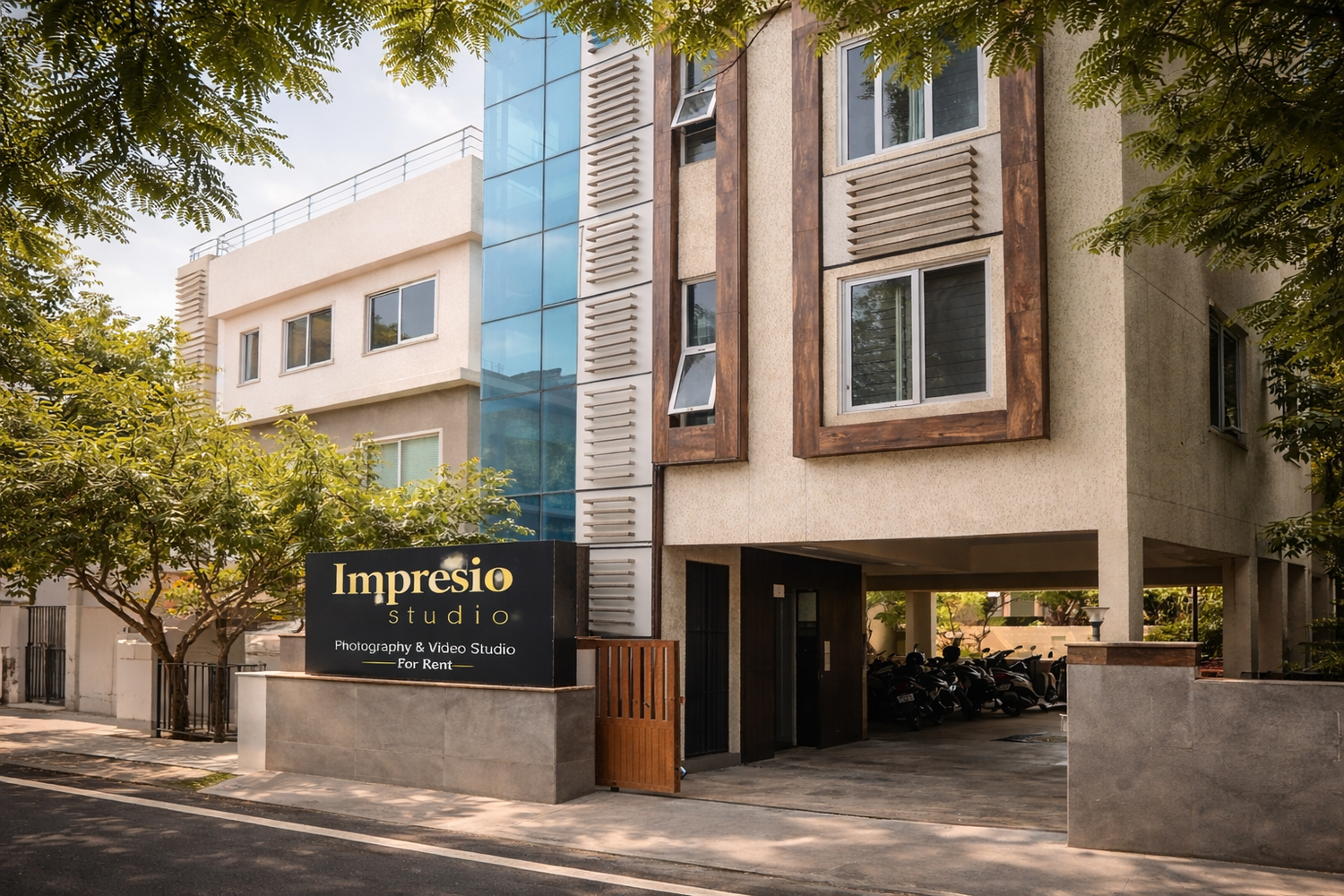 Modern office building exterior with glass windows and trees framing the entrance walkway and facade.