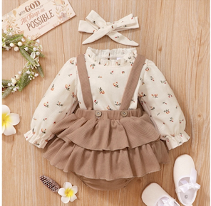 Brown and white frilly baby rompers with floral patterns and bow details.