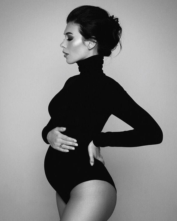 Classic black and white maternity portrait in fitted turtleneck bodysuit.