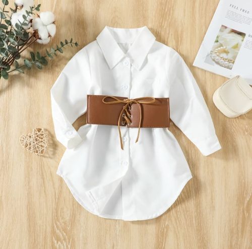 White collared shirt with brown lace-up corset belt styled on wooden background.