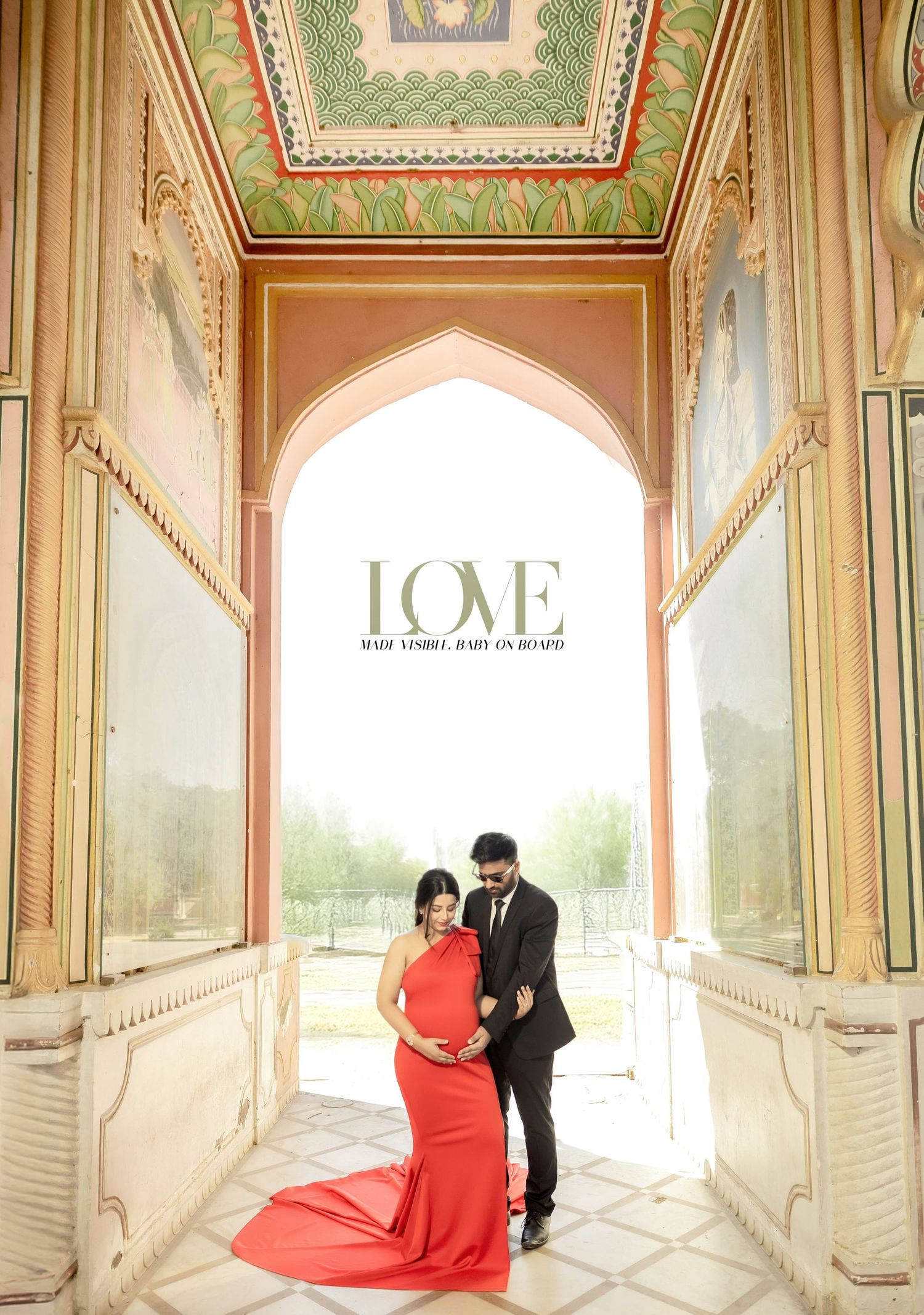 Elegant maternity photo in red gown under ornate architectural archway with decorative ceiling.