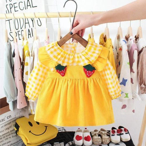 Yellow gingham baby dress with strawberry appliques displayed in clothing store.