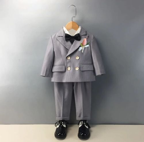 Formal grey baby suits with white shirts and bow ties displayed on hangers.