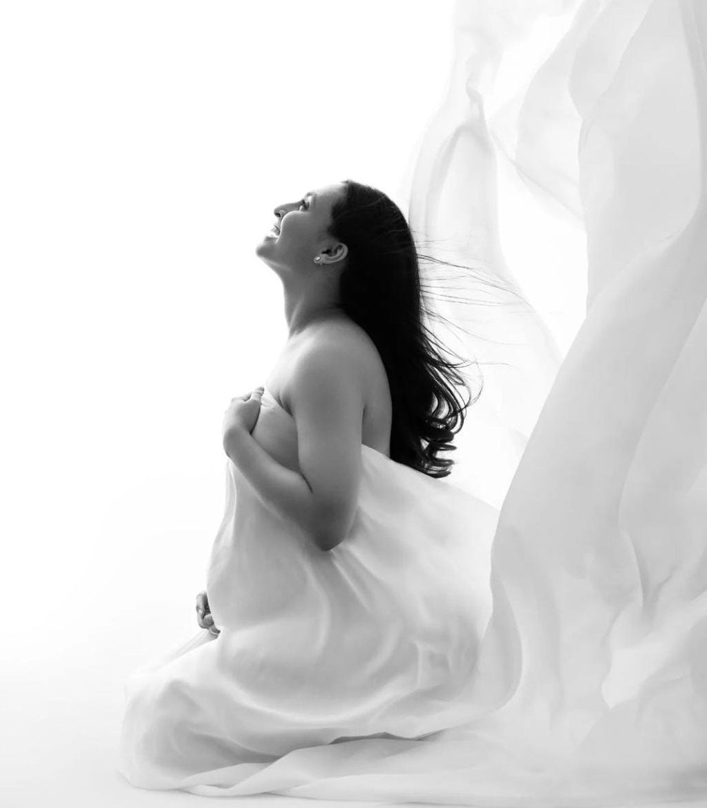 Ethereal maternity portraits with white flowing fabric creating silhouettes.