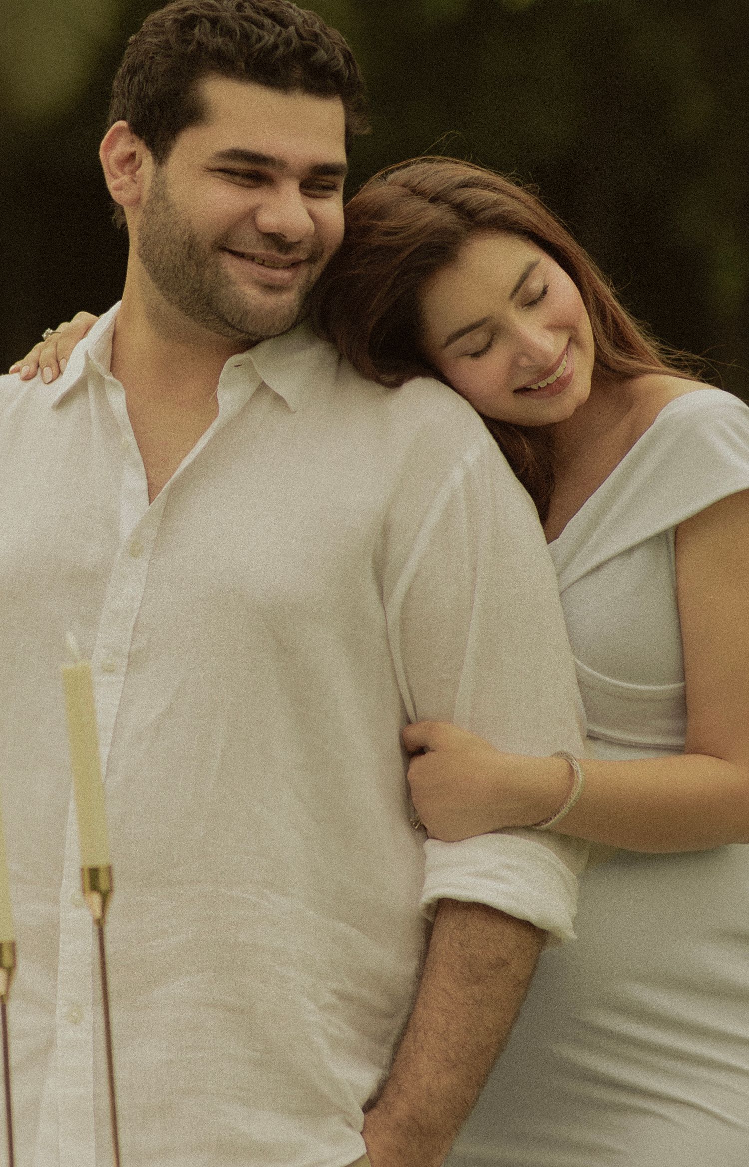 A couple wearing white outfits share affectionate moments together in a series of romantic outdoor photos.