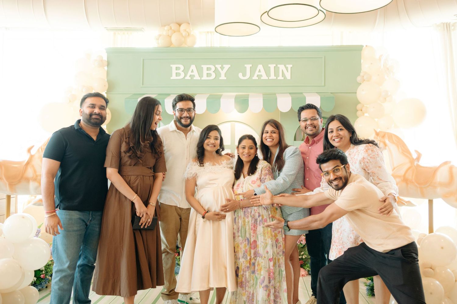 Group of friends and family celebrating a Baby Jain baby shower with balloons and decorations.