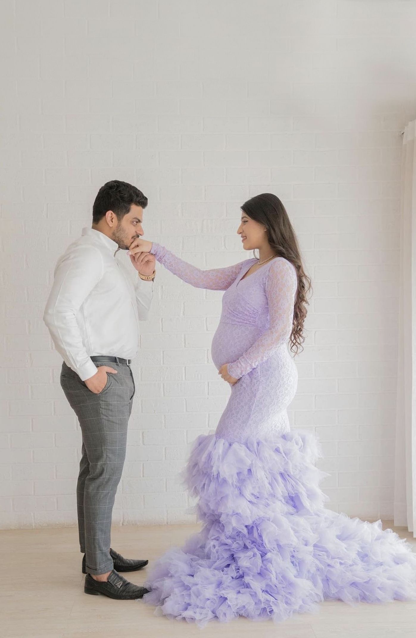 Romantic maternity dance poses in a white studio with a flowing purple tulle gown.