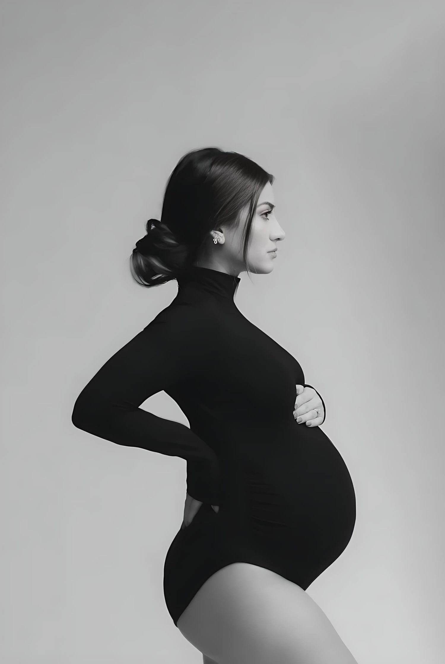 Classic black and white maternity profile portrait in bodysuit.