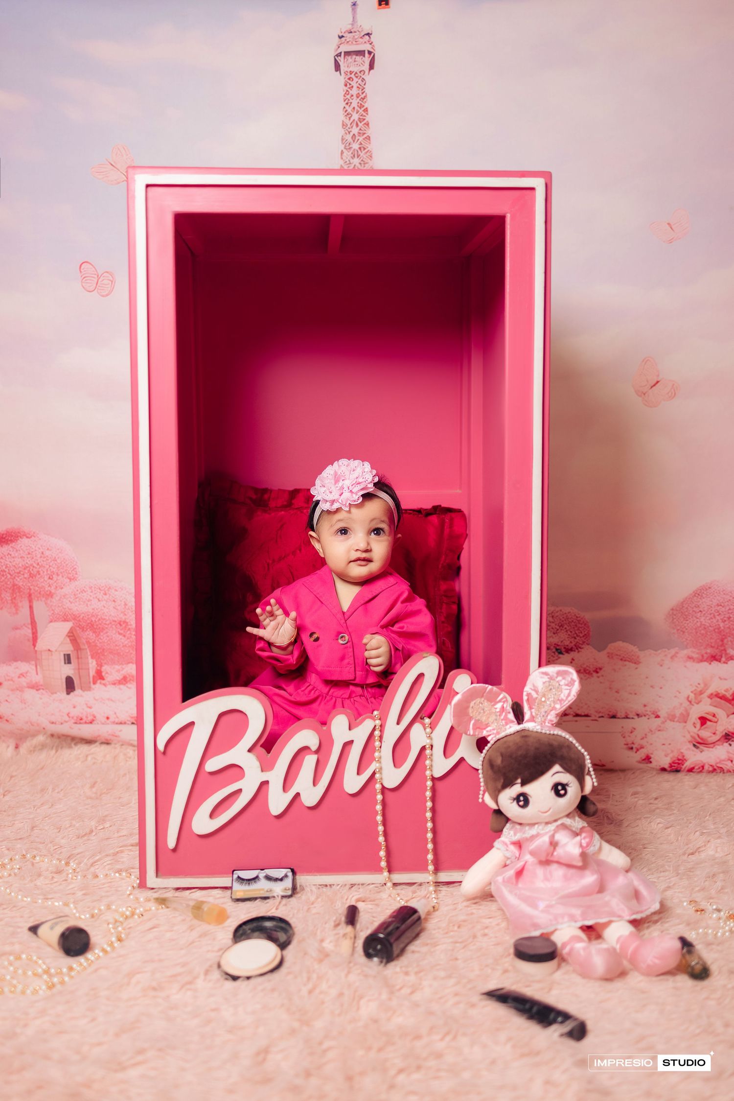 A pink Barbie-themed photo series showing a toy box with dolls and decorative elements in a dreamy pink setting.