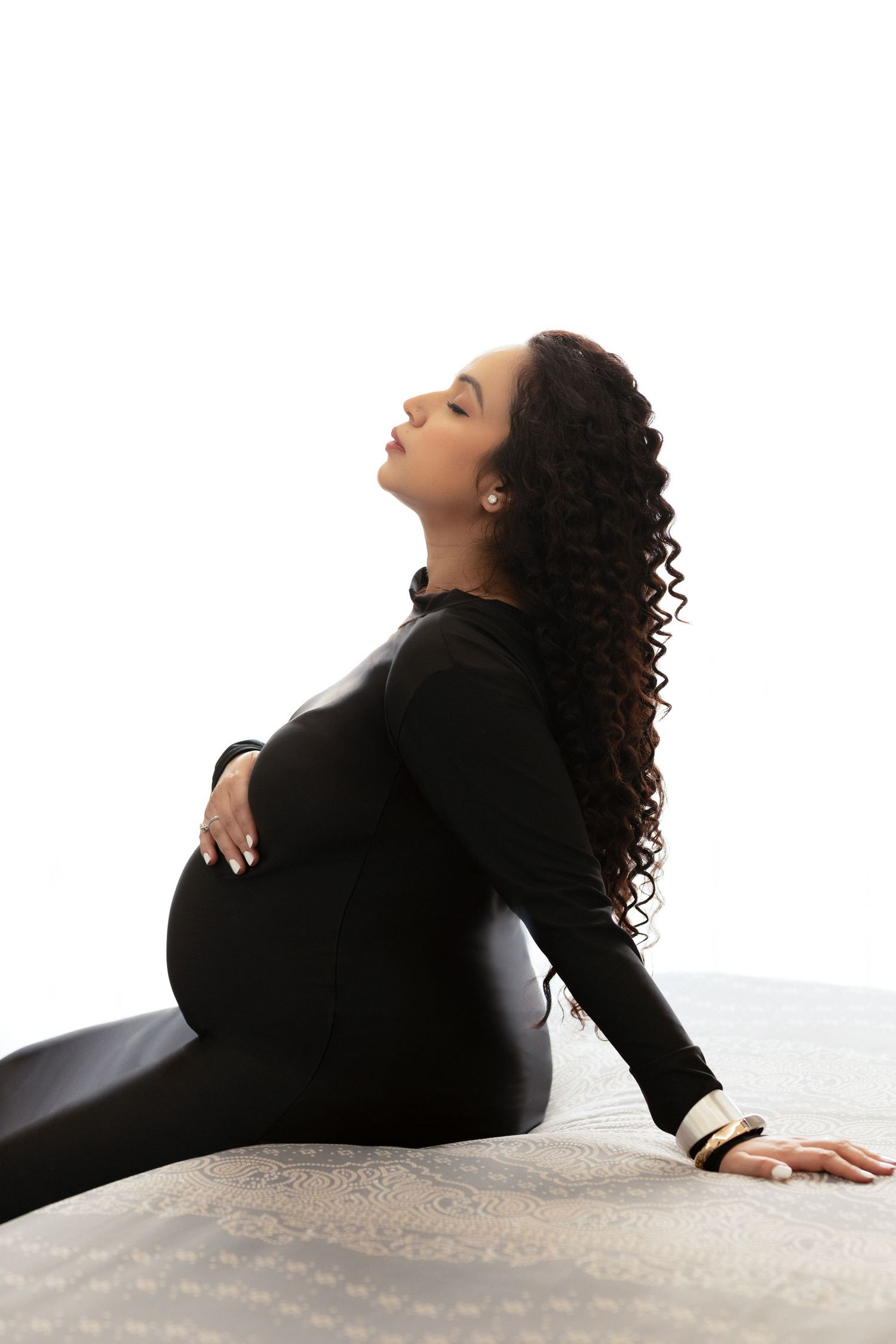 A person in a black sweater reclines on a white surface in a series of artistic poses showing graceful movement.