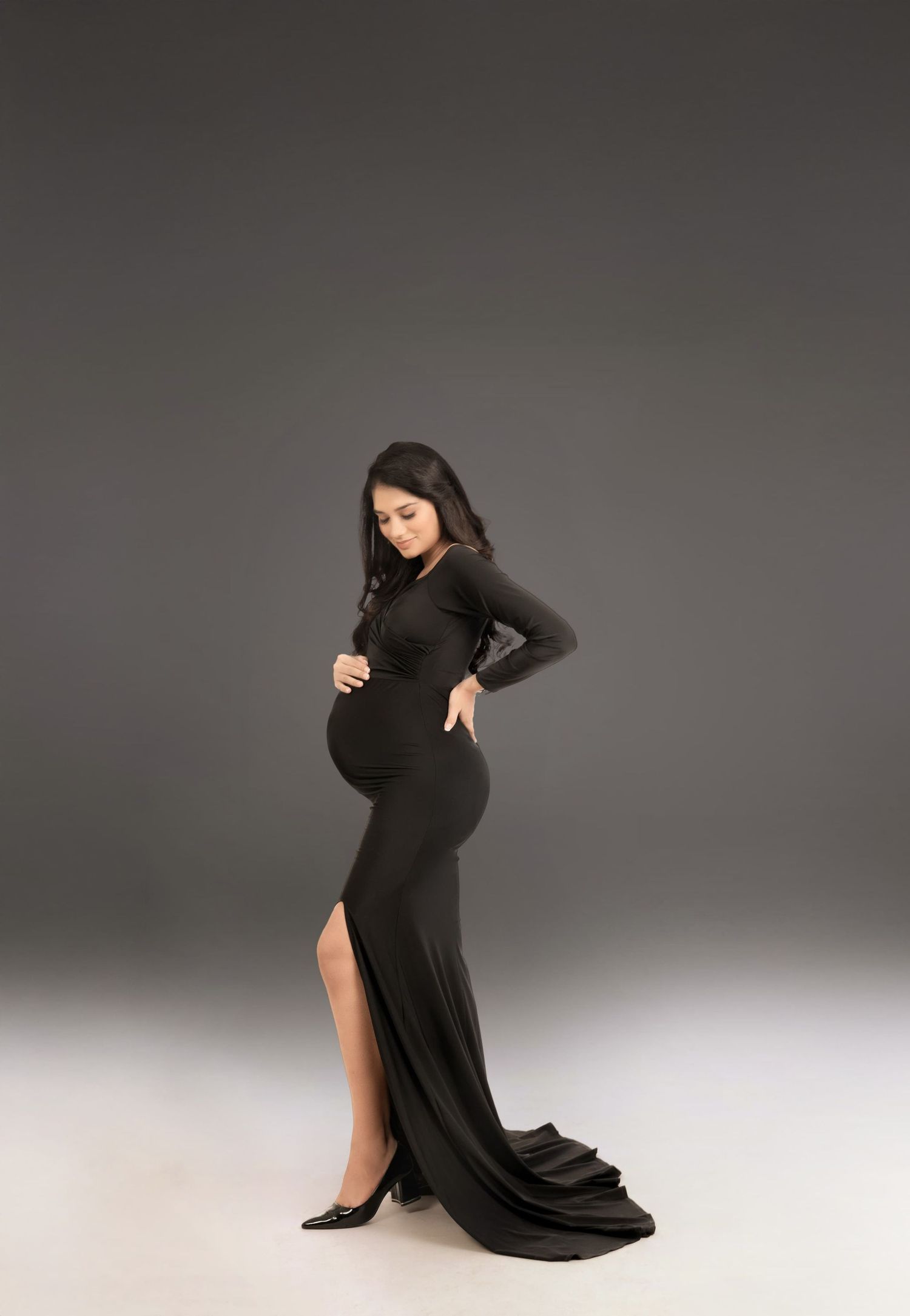 Modern maternity photography featuring sleek black dress and graceful poses.