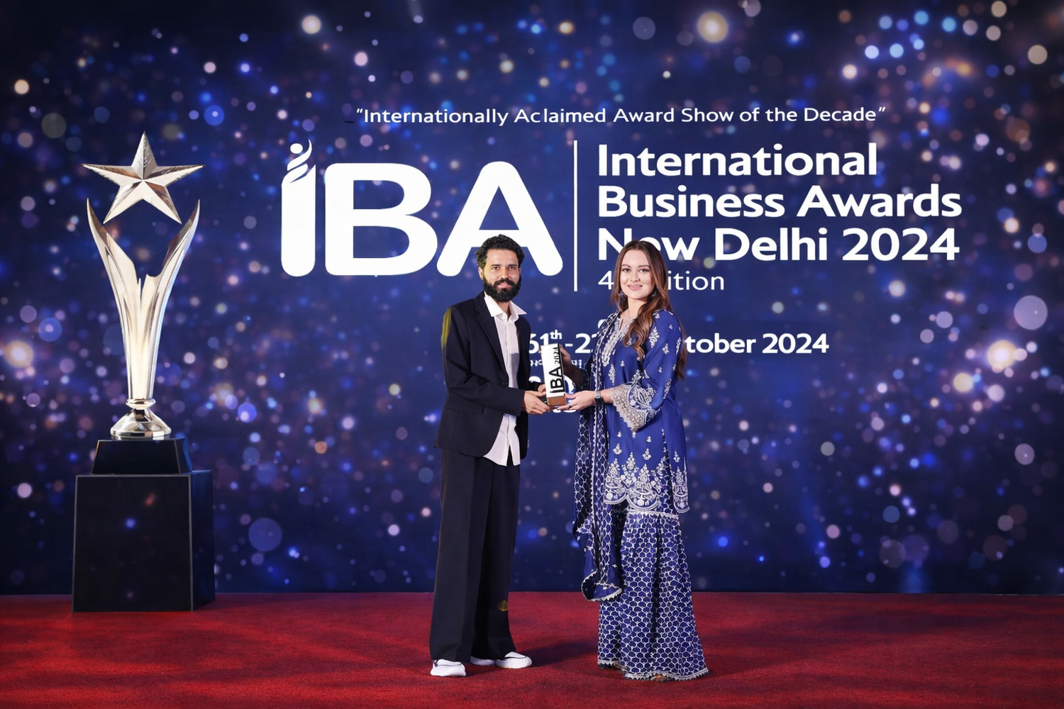 Two people accepting an award on stage at the International Business Awards 2024 ceremony in New Delhi.