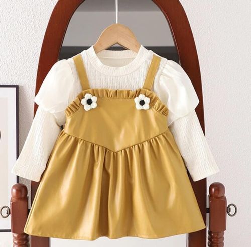 Yellow baby dress with white flower accents and matching short-sleeve top displayed on wooden hanger.