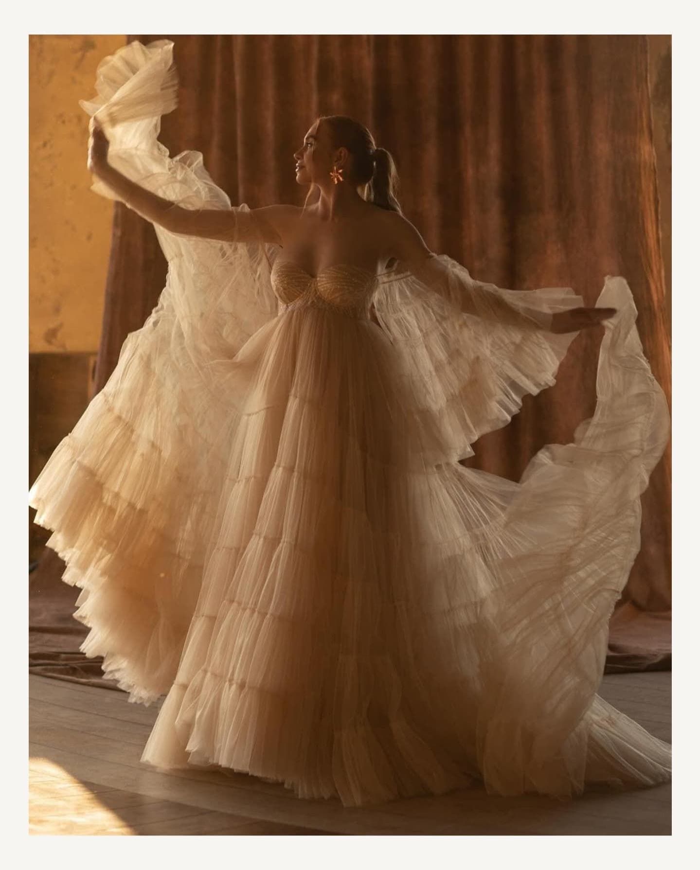 Elegant wedding dress details photographed with dramatic lighting and flowing fabric.