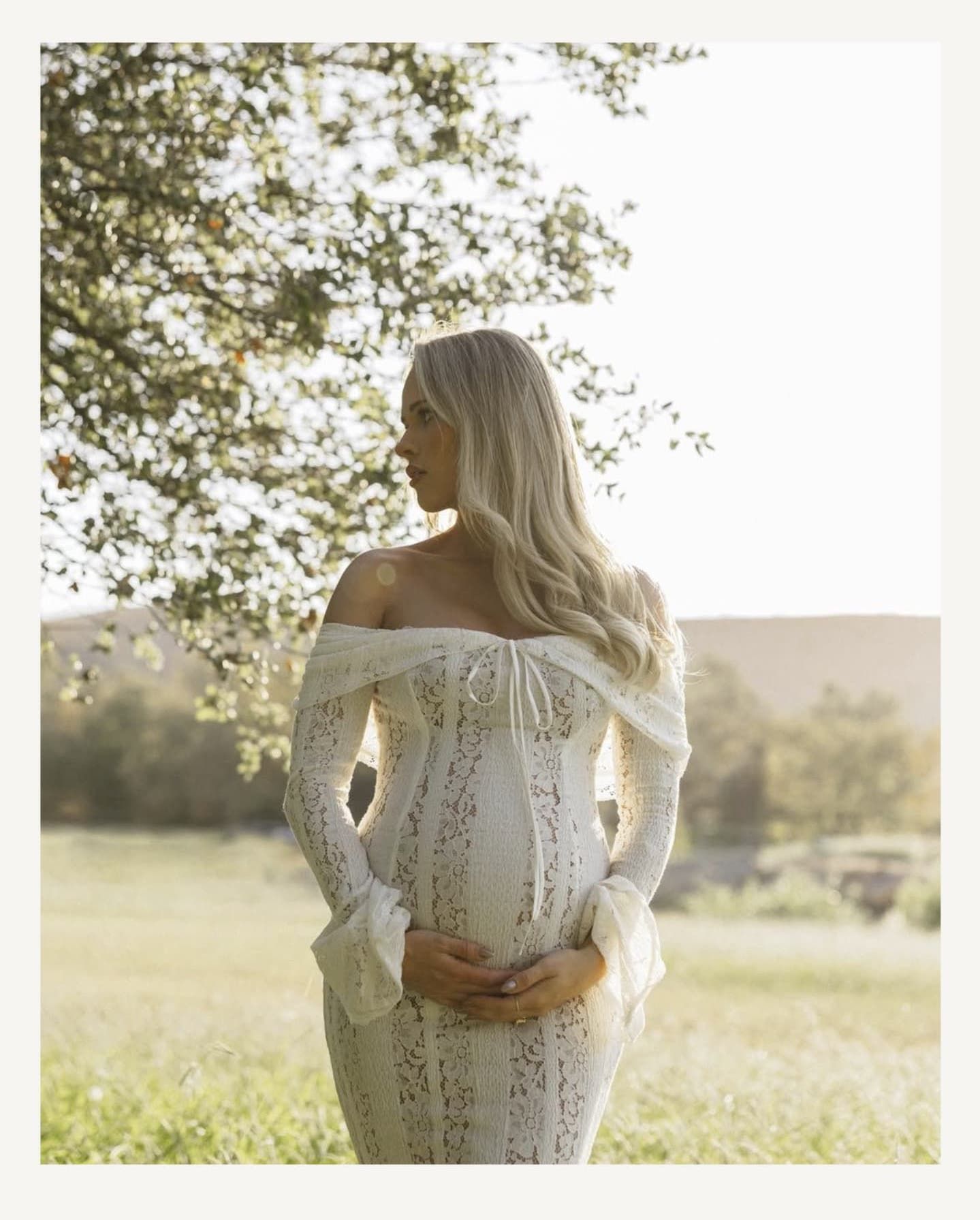 Ethereal white lace dress details captured in soft sunlight against a natural outdoor backdrop.
