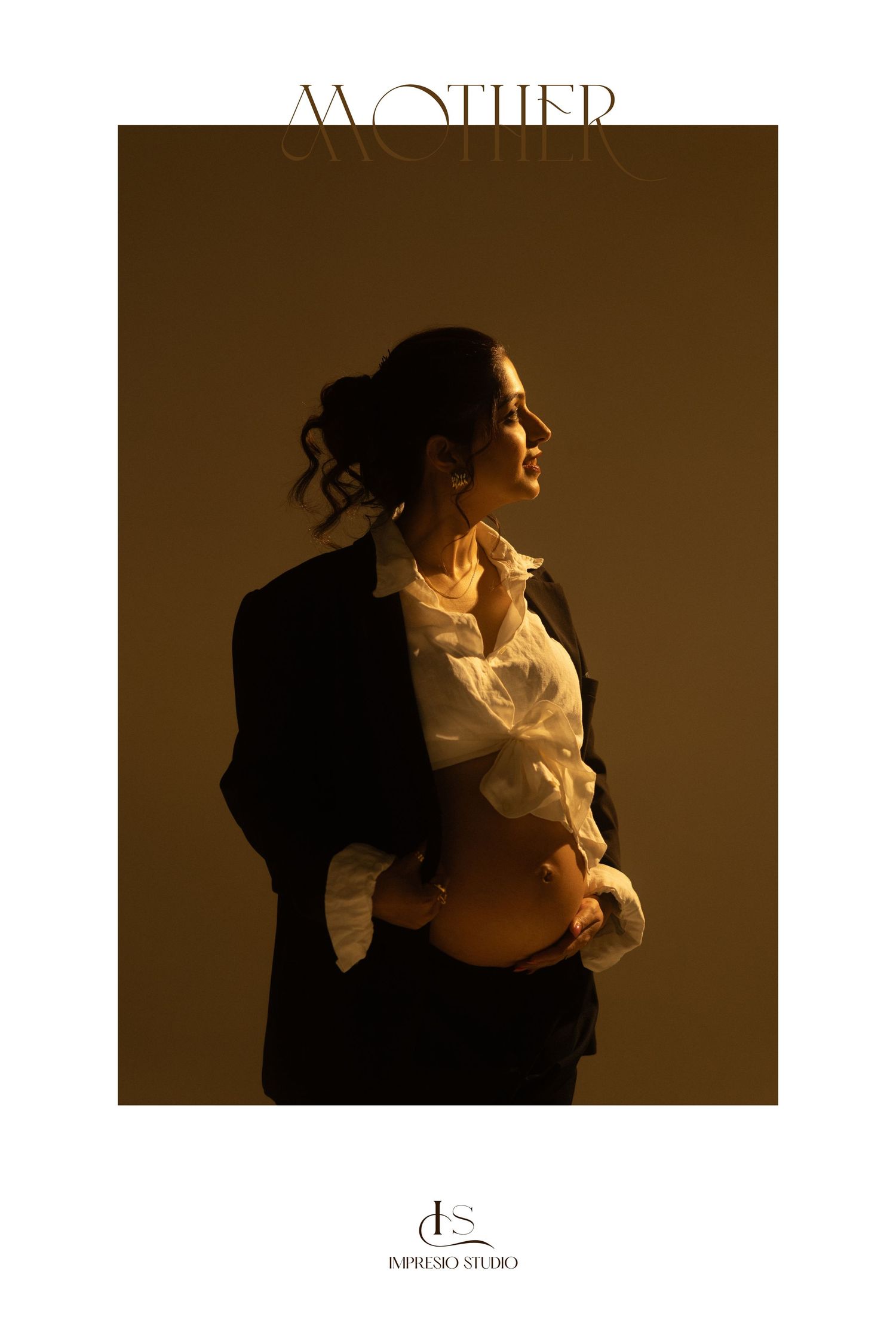 Silhouetted figures in warm sepia tones embrace tenderly against a dark background creating an intimate artistic portrait.