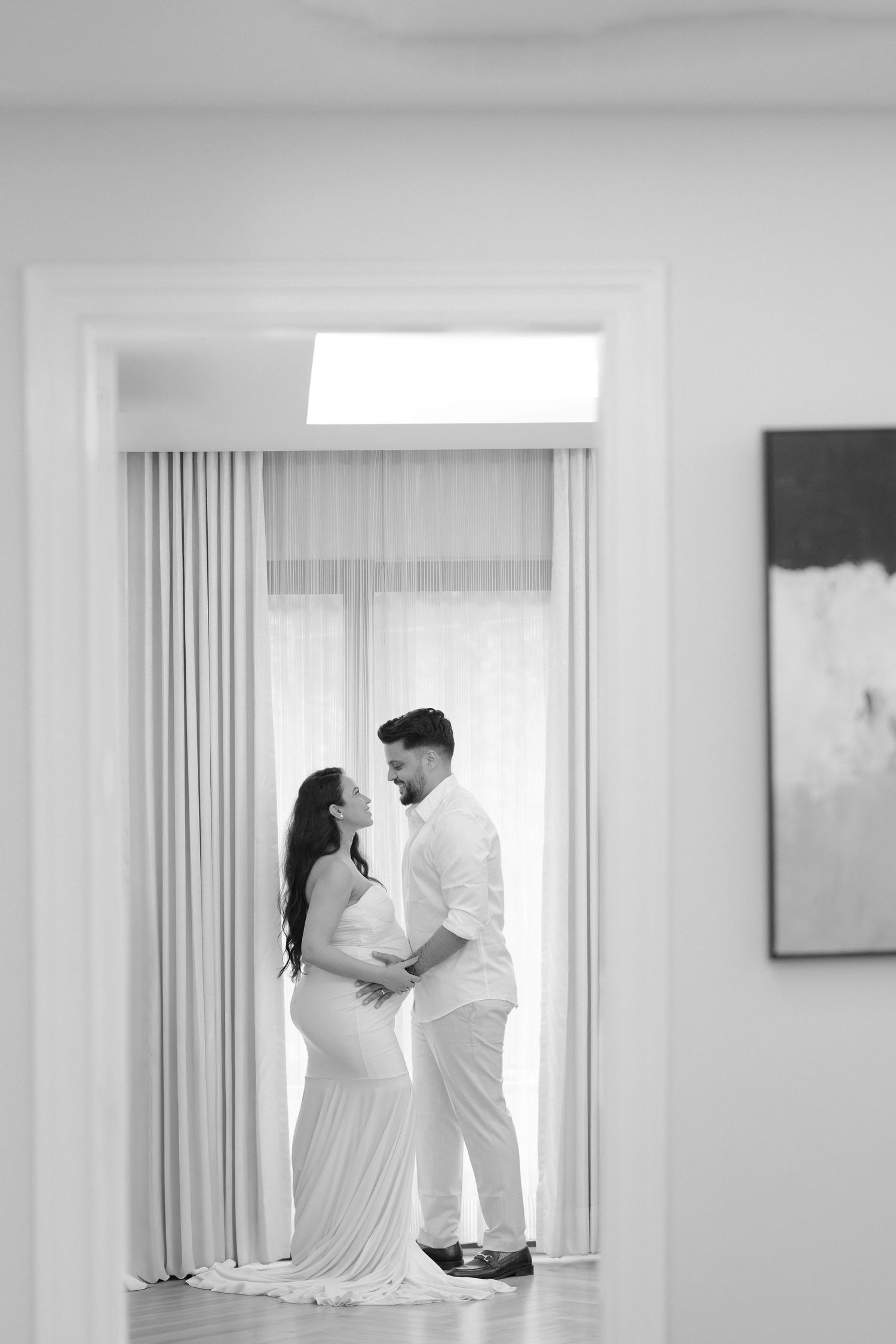 A romantic maternity photoshoot sequence showing a couple in white outfits against a light background.
