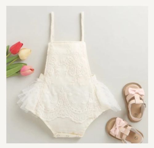 White lace baby romper with matching shoes displayed on light background.