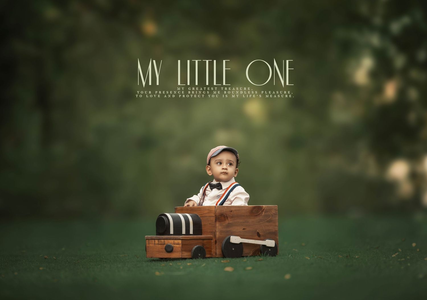 A cute baby boy in vintage suspenders sits inside a wooden toy train on a green outdoor backdrop.