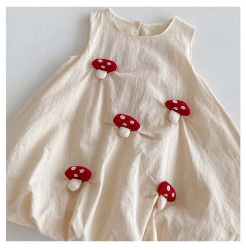 White bubble dress adorned with red and white spotted mushroom decorations.