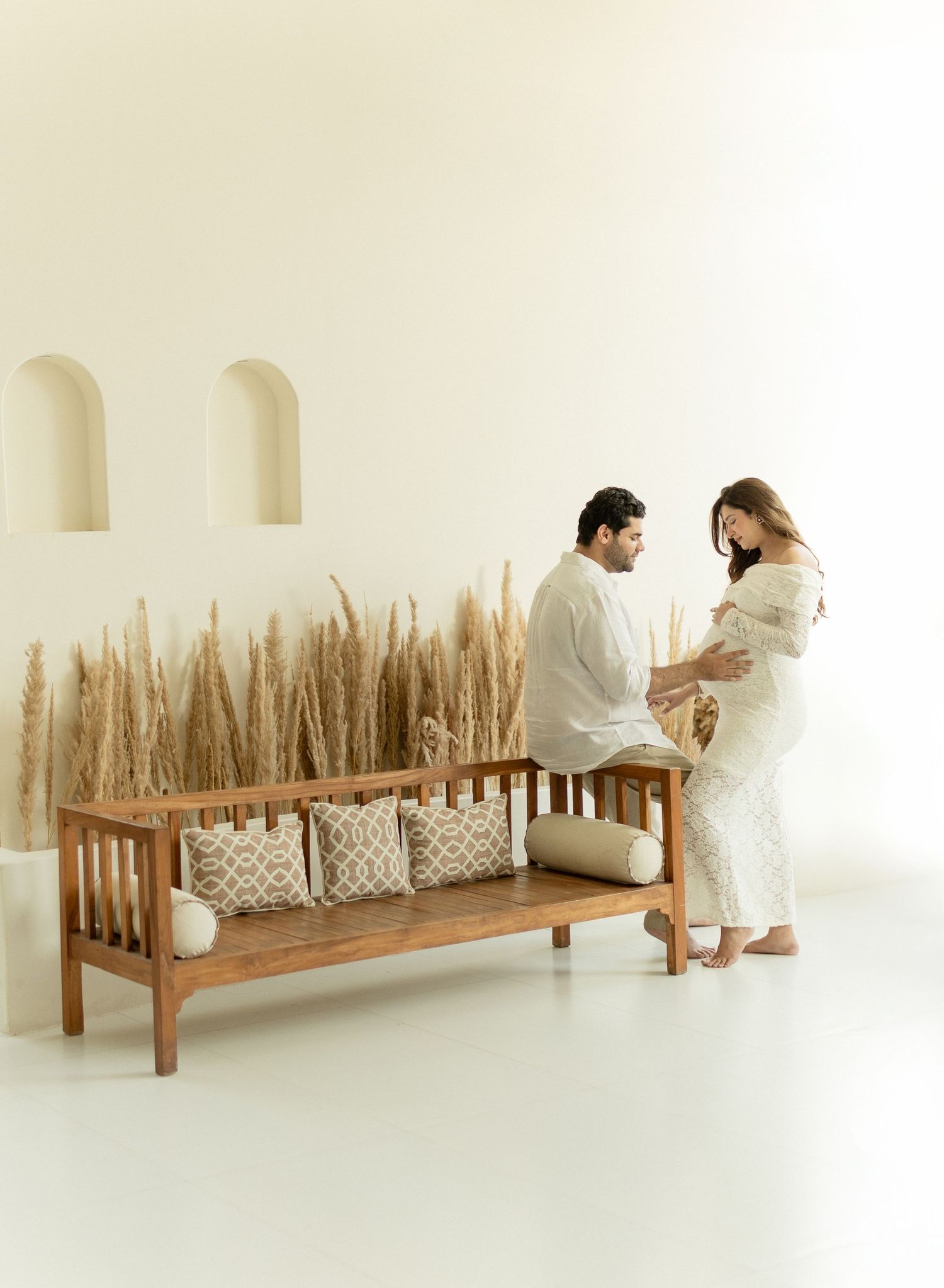 Conceptual art piece showing a repetitive sequence of two people in white robes sitting on wooden benches with wheat stalks.