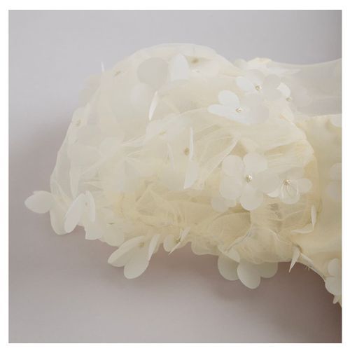 Close-up of delicate ivory tulle fabric with floral appliques.