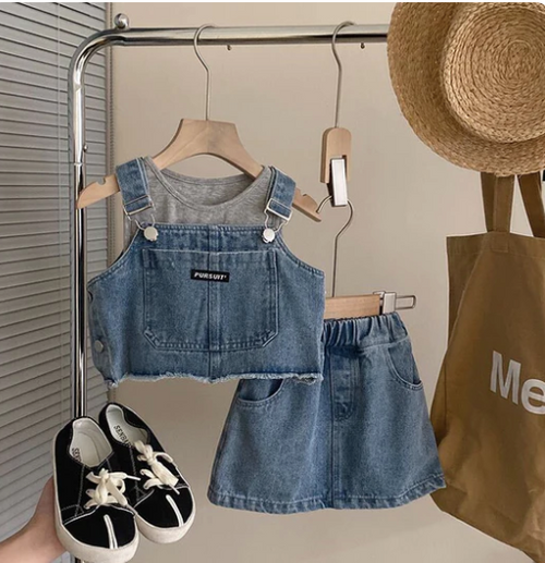 Denim two-piece outfit with crop top and skirt displayed with accessories and shopping bag.