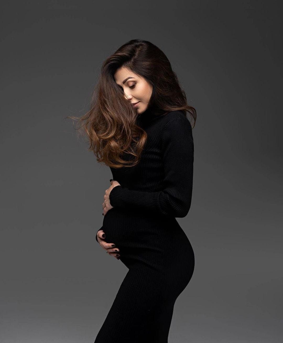 Dramatic fashion portraits in black attire against dark background with dynamic hair movement.