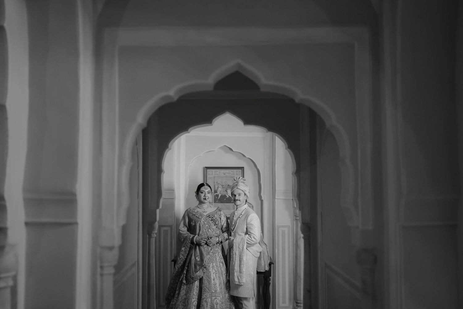 A grand interior hallway with arched columns and ornate architectural details in black and white.