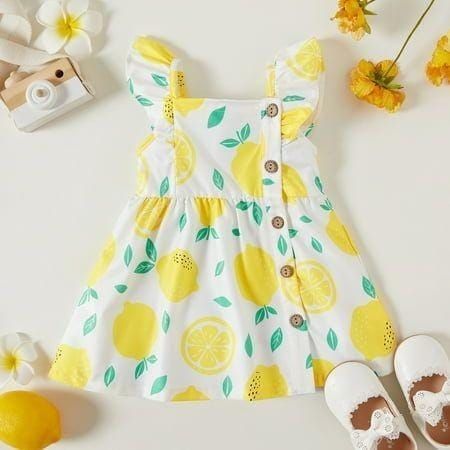 Yellow and white summer dress with lemon print pattern and decorative buttons.