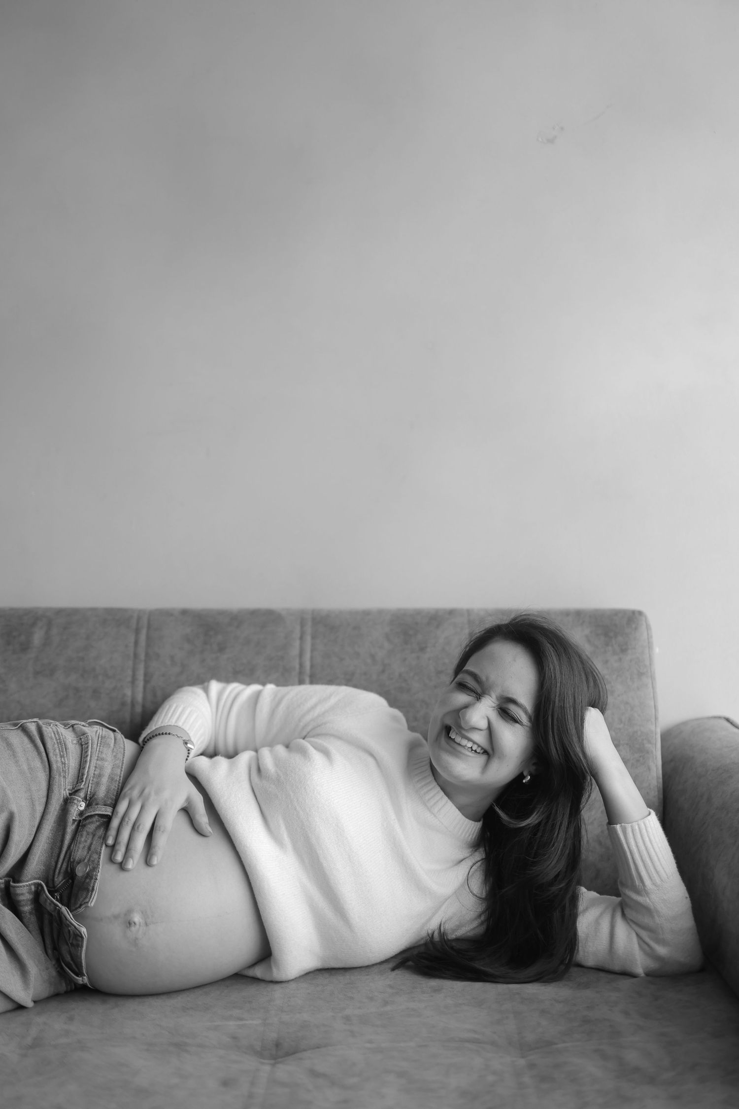 A series of black and white photos showing a person lying on their side in a contemplative pose against a wall.