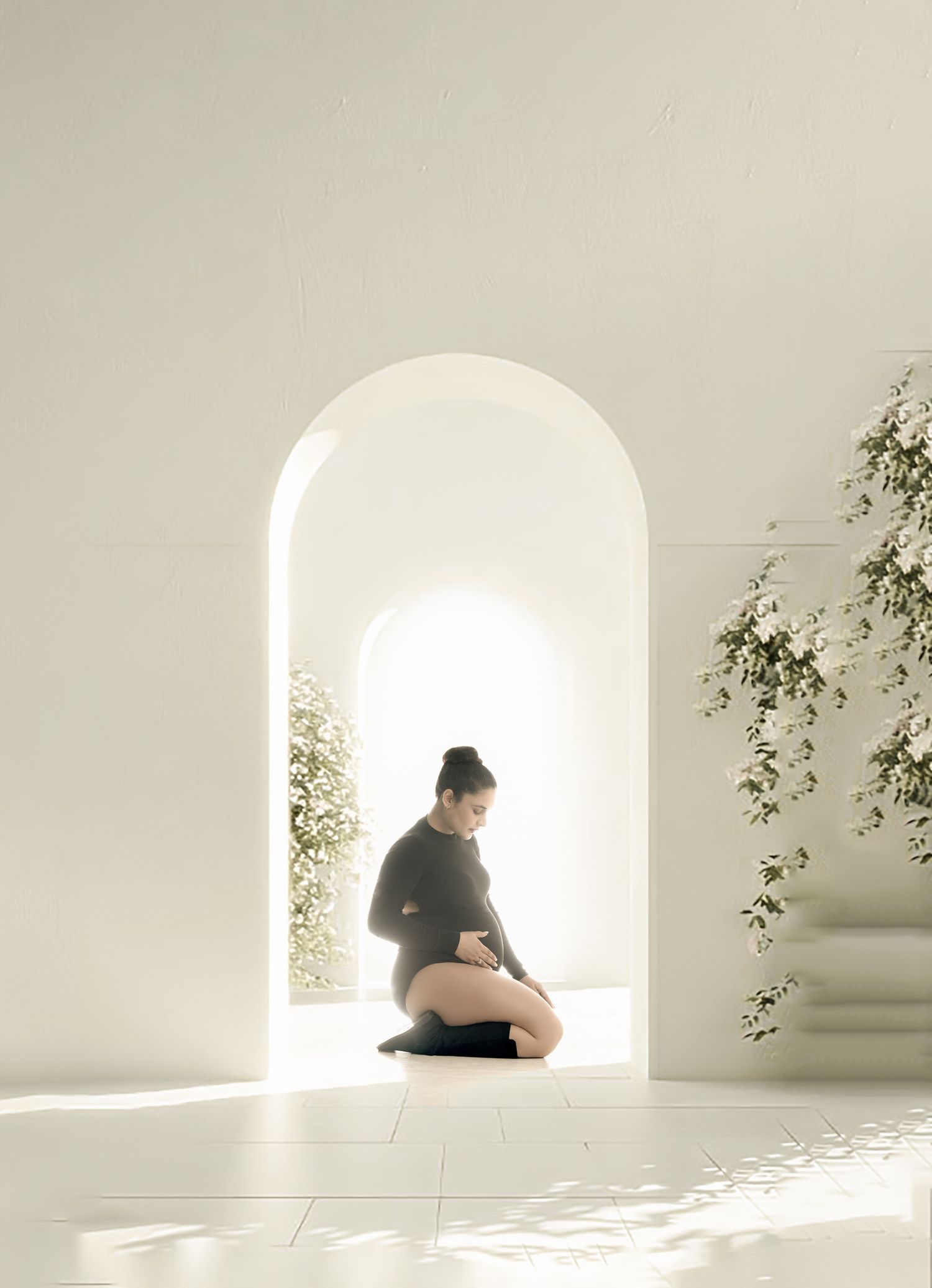 Silhouette of person sitting for minimalist photoshoot in a white space with arched doorway and climbing vines creating ethereal atmosphere.
