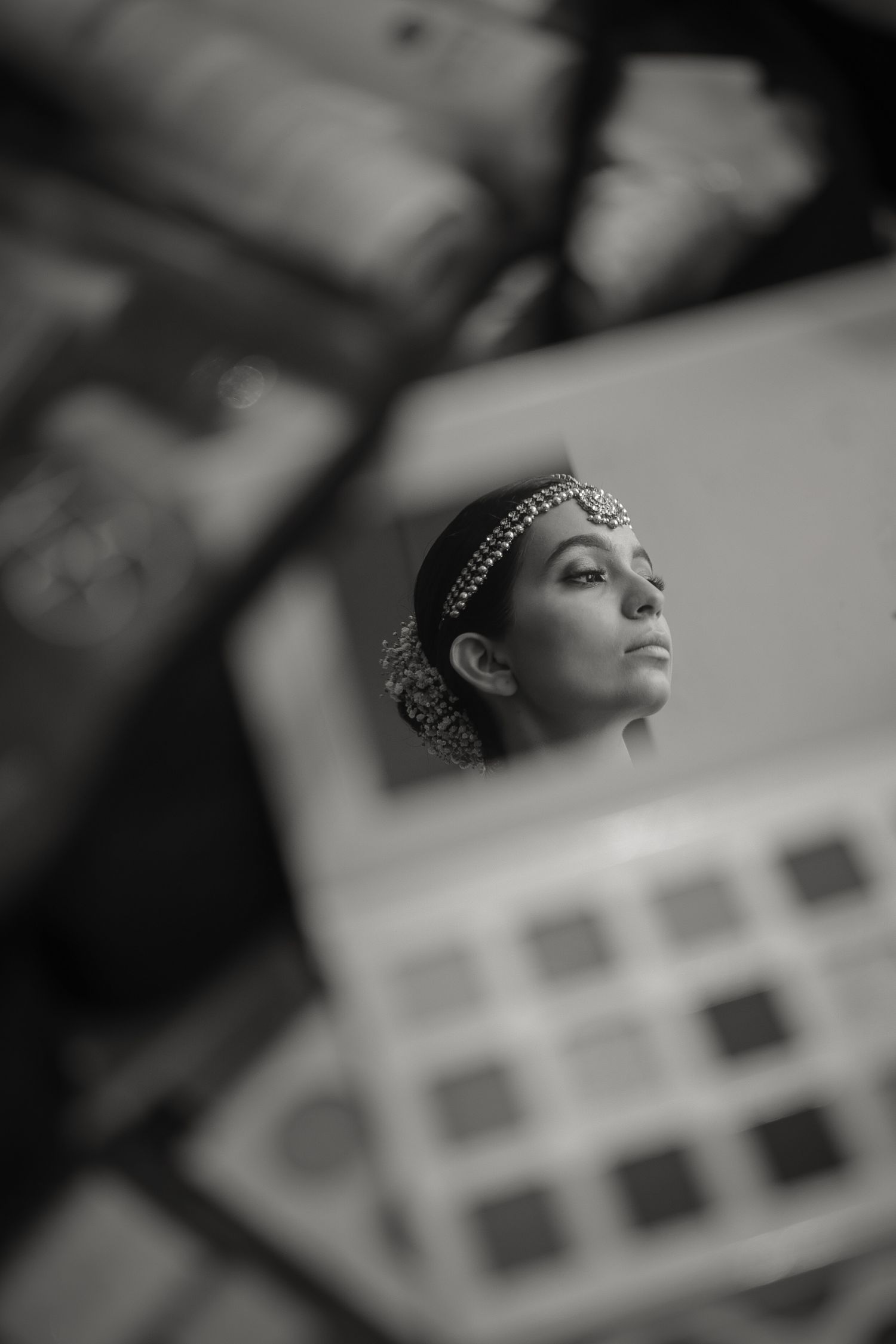 Artistic black and white portrait showing traditional Indian bridal jewelry and accessories.