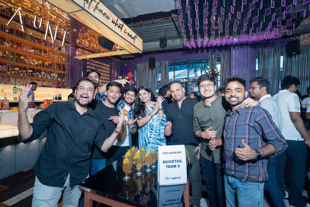 Group of friends posing and smiling at a vibrant nightclub bar, holding drinks and celebrating together.