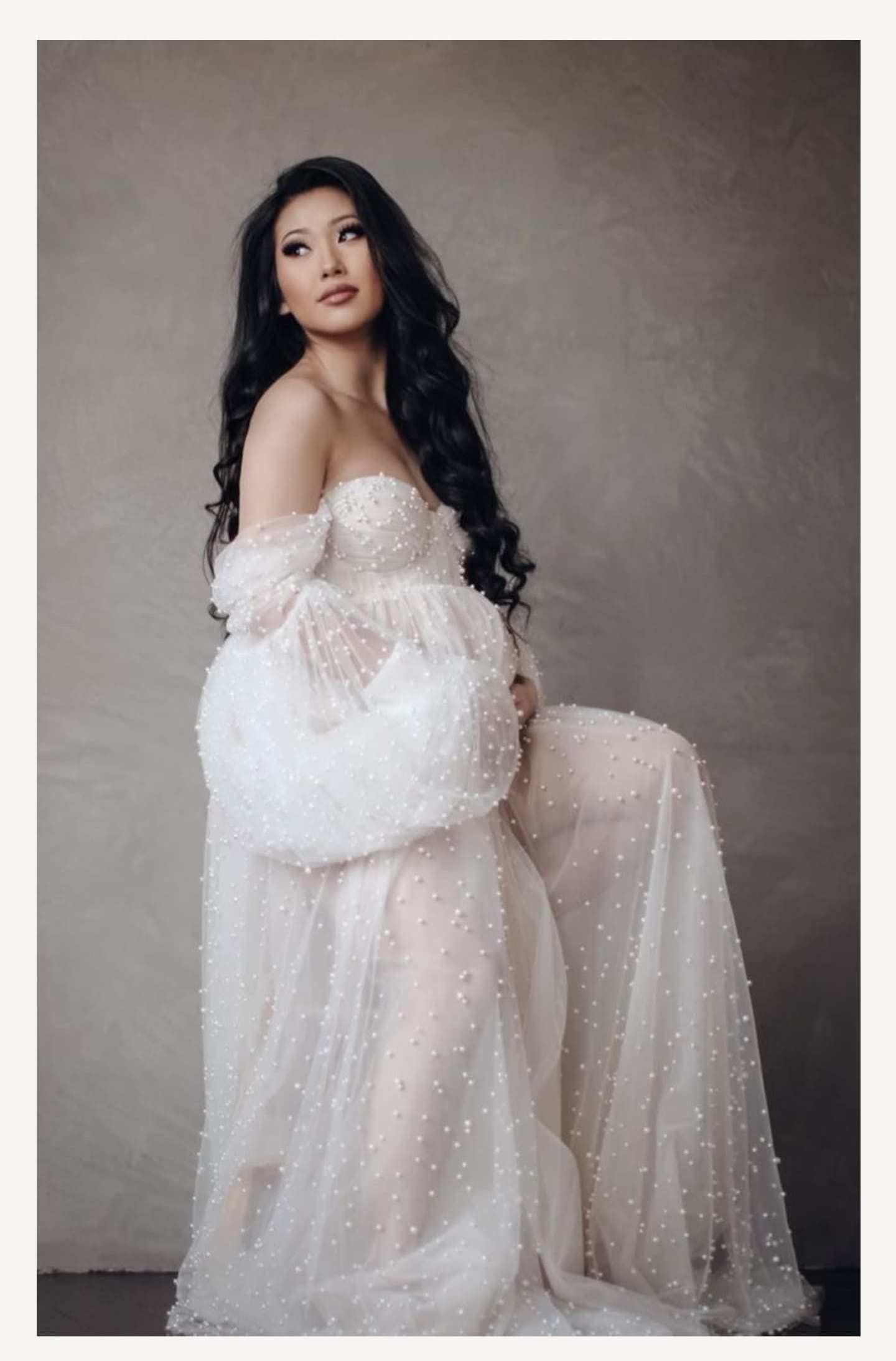 Dreamy maternity photography session with flowing white pearl-studded gown.