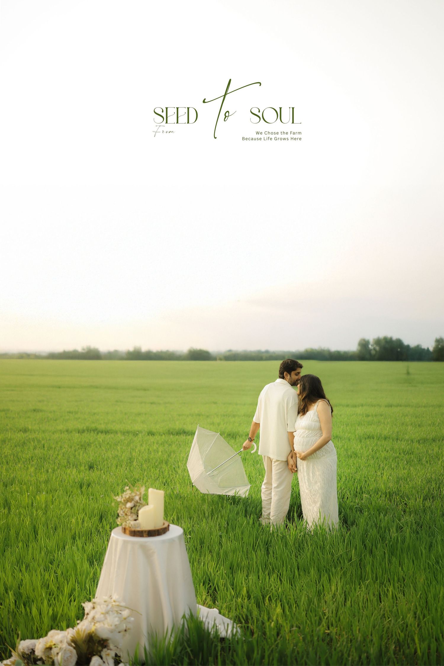 A romantic outdoor scene in a lush green field with a decorated table and white floral arrangements at sunset.