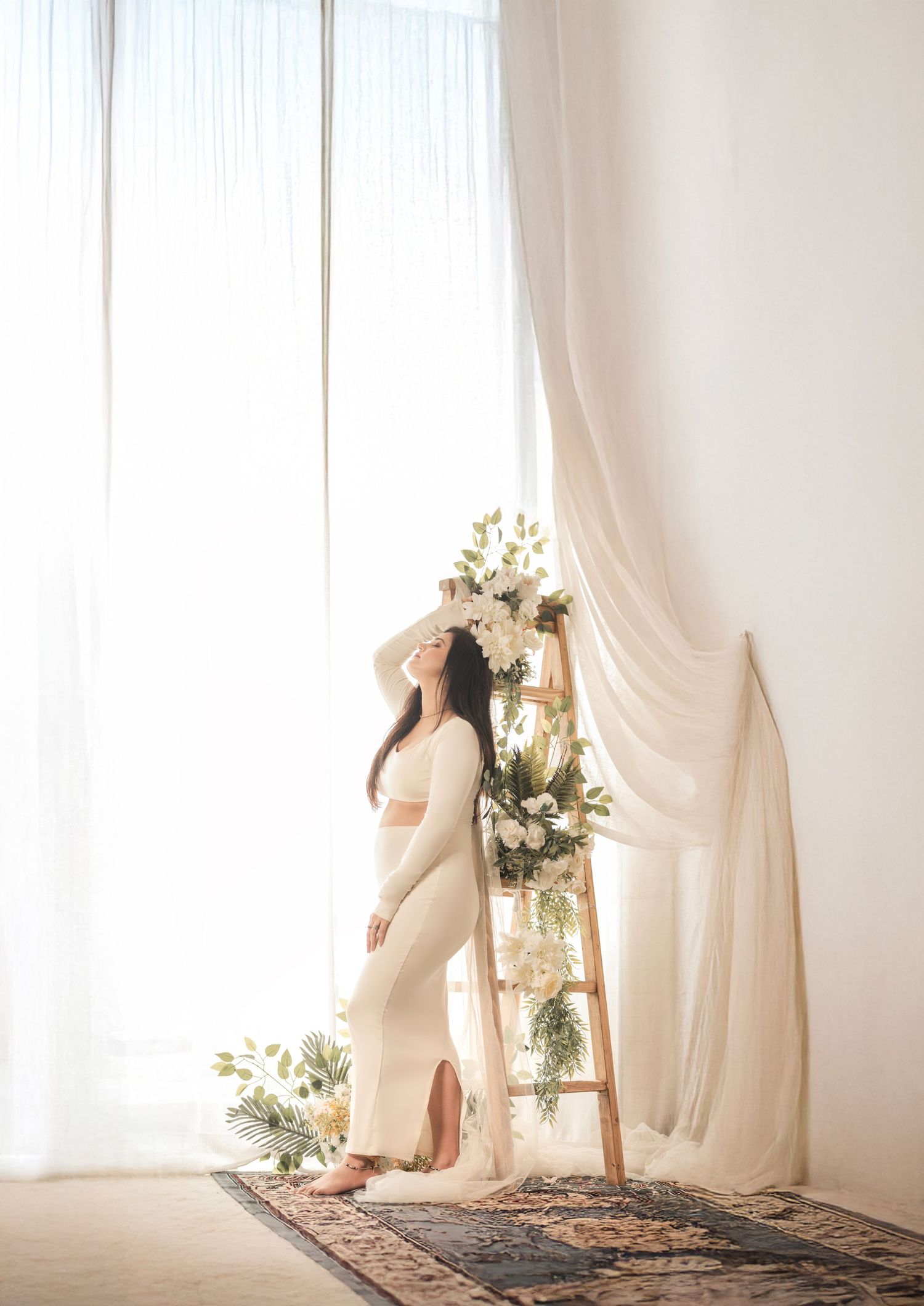 Ethereal white curtains flow in a bright minimalist room with delicate floral arrangements creating a dreamy atmosphere.