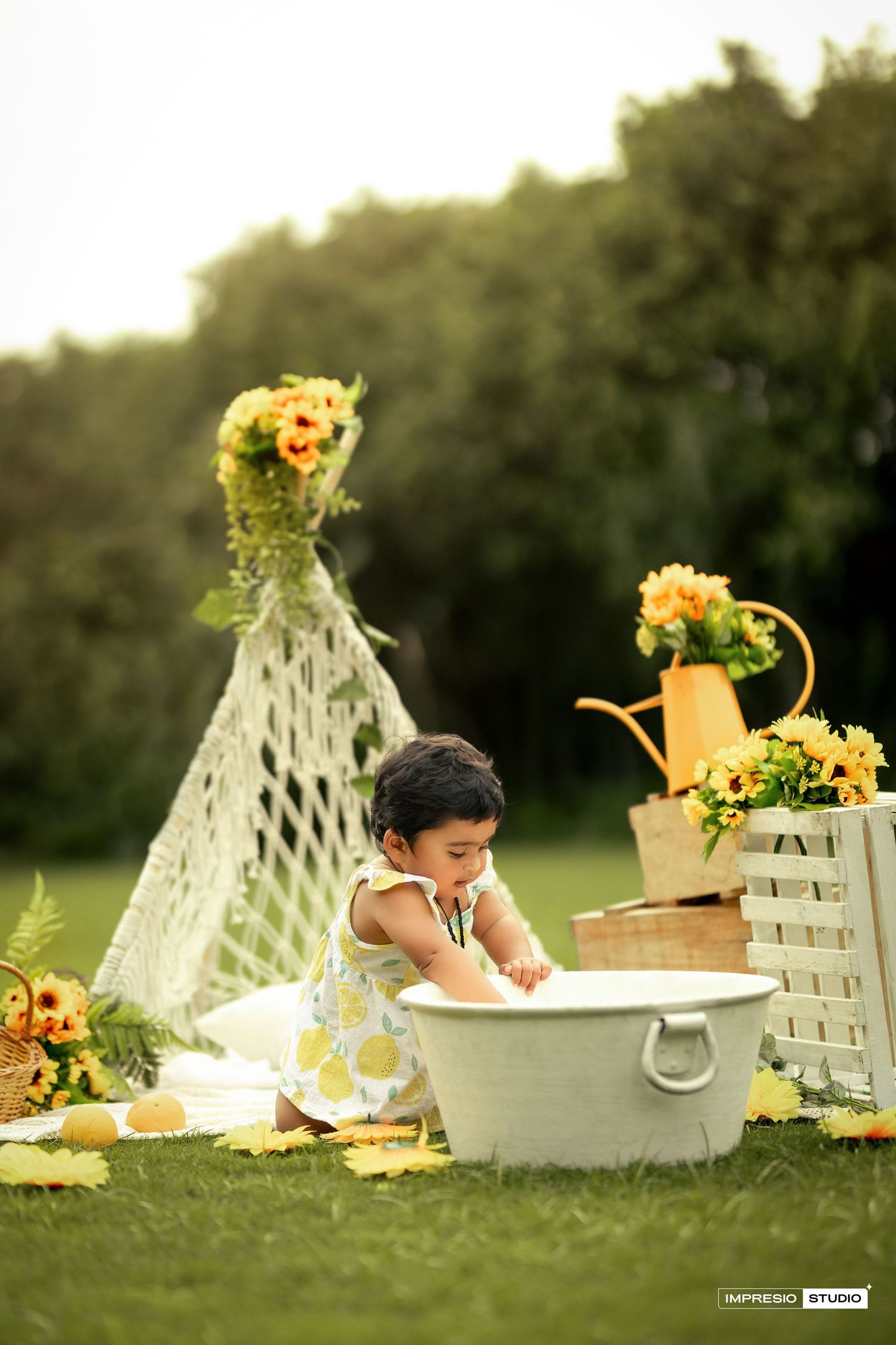 Outdoor garden scene with vintage washtub, lace decor, yellow flowers and sunflower arrangements in rustic setting.