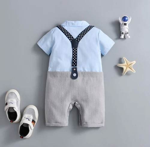 Baby boy romper with polka dot suspenders, white shoes, and decorative star and astronaut accessories.