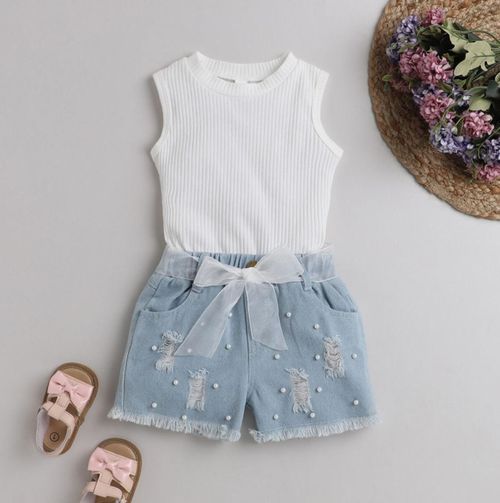 White ribbed top paired with light blue denim shorts and bow detail.