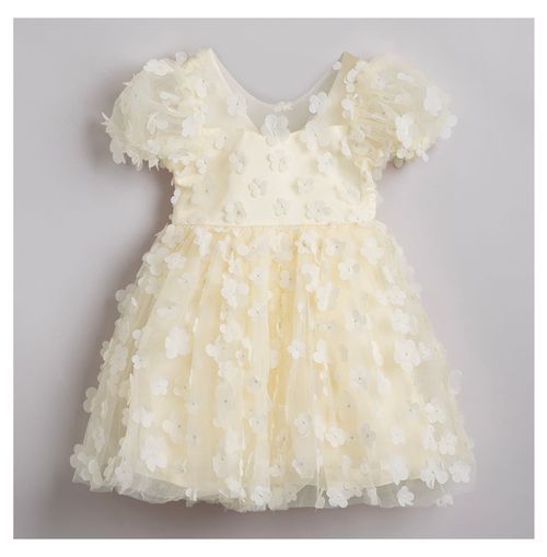 Romantic cream colored party dress with tulle flowers and puff sleeves.