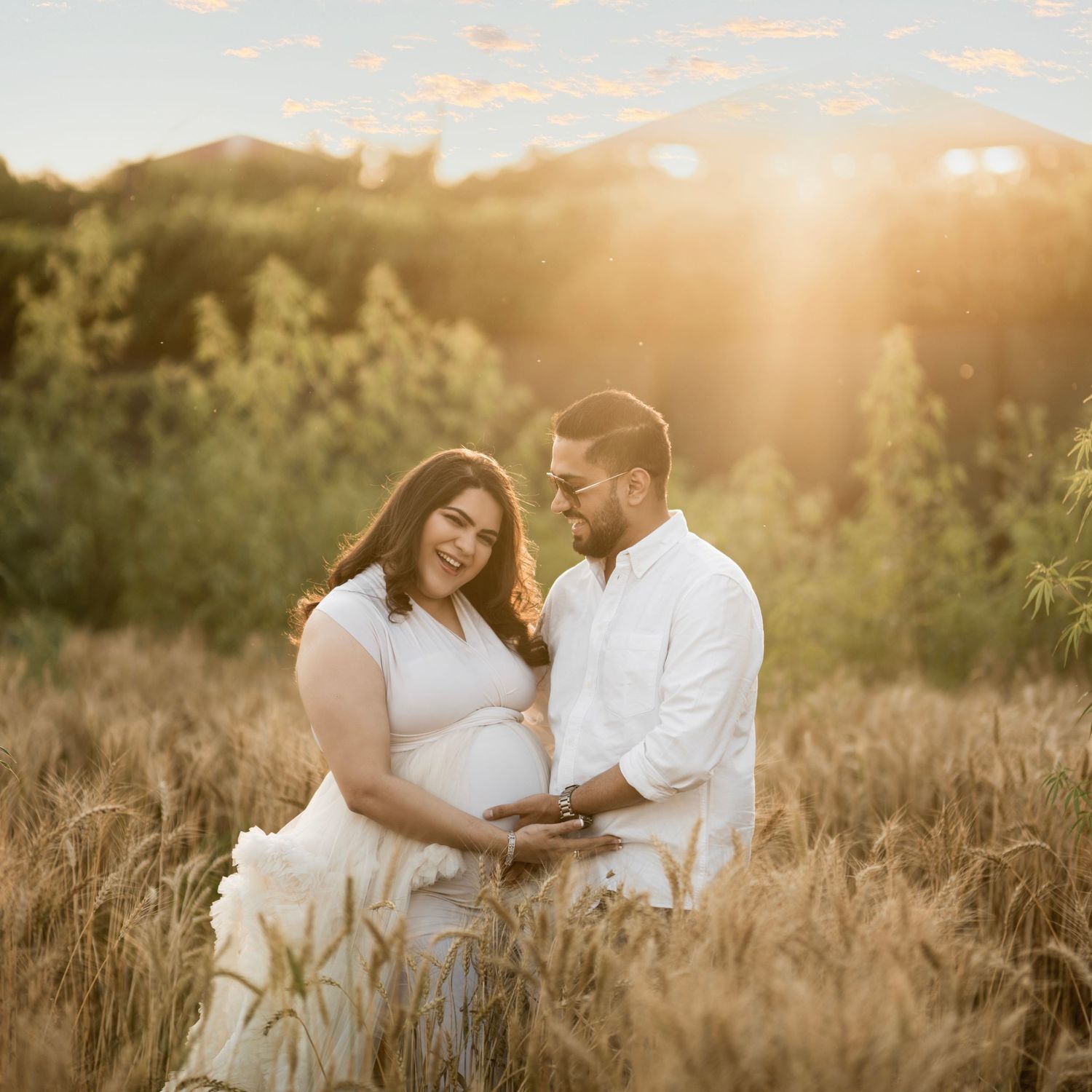 Romantic sunset maternity session in a golden wheat field.