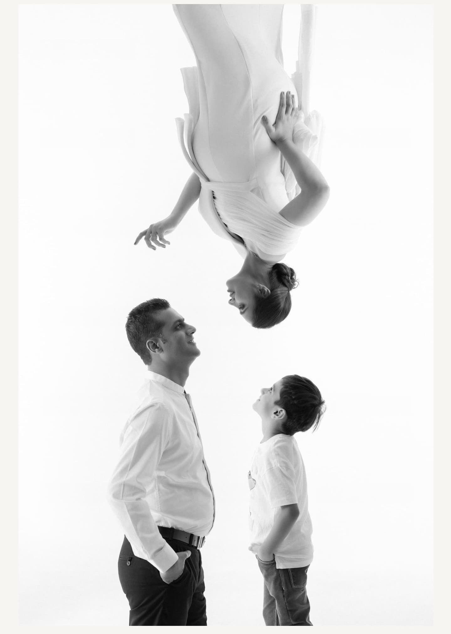 Black and white photo series showing a couple posing in formal attire against a white backdrop.