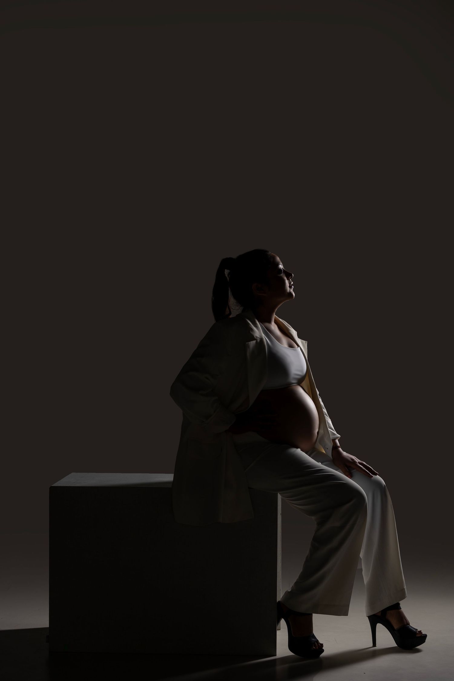 Moody artistic portraits with dramatic lighting and shadows on dark set.