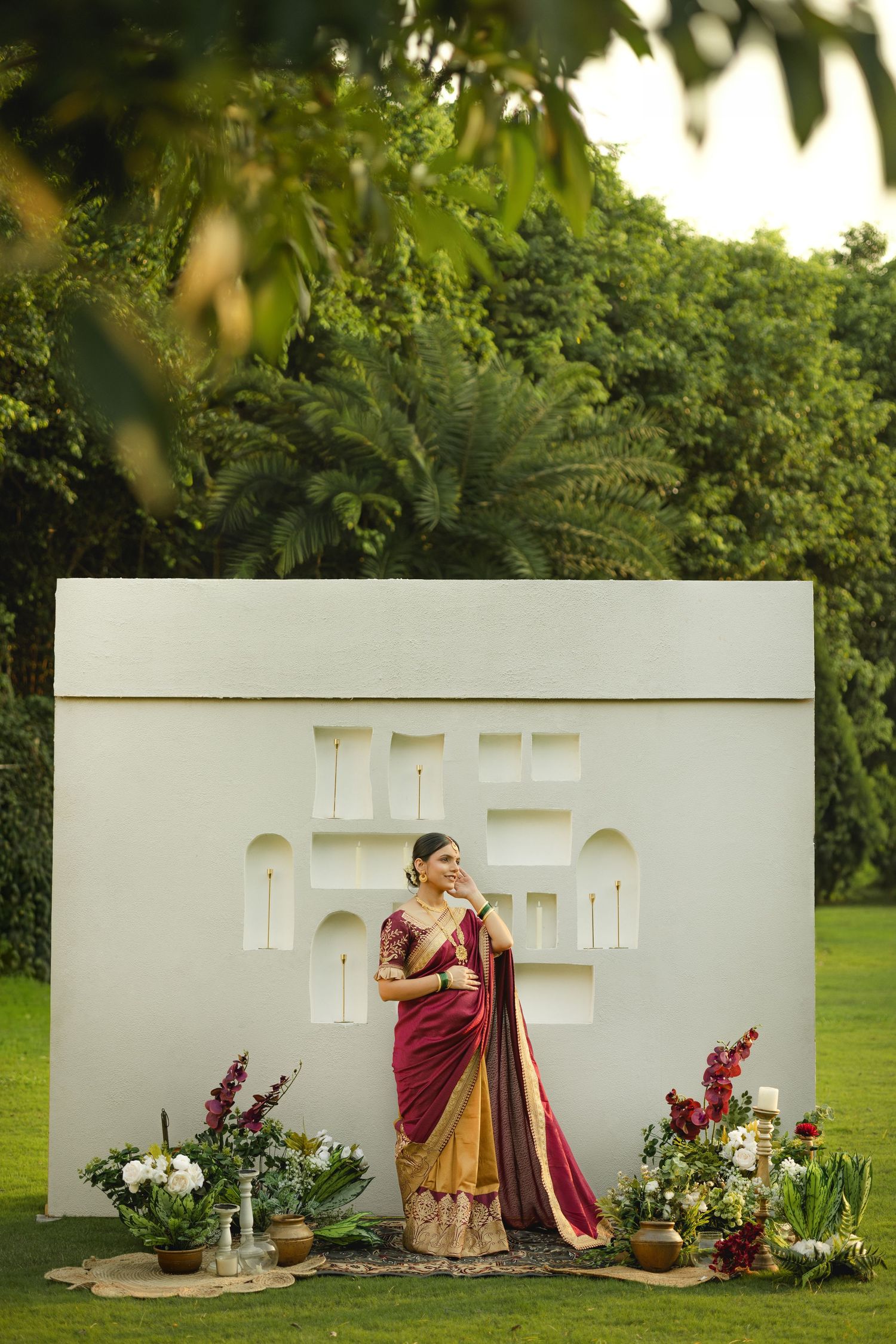 A creative wedding photo sequence showing a white backdrop with floral arrangements and burgundy attire in an outdoor garden setting.