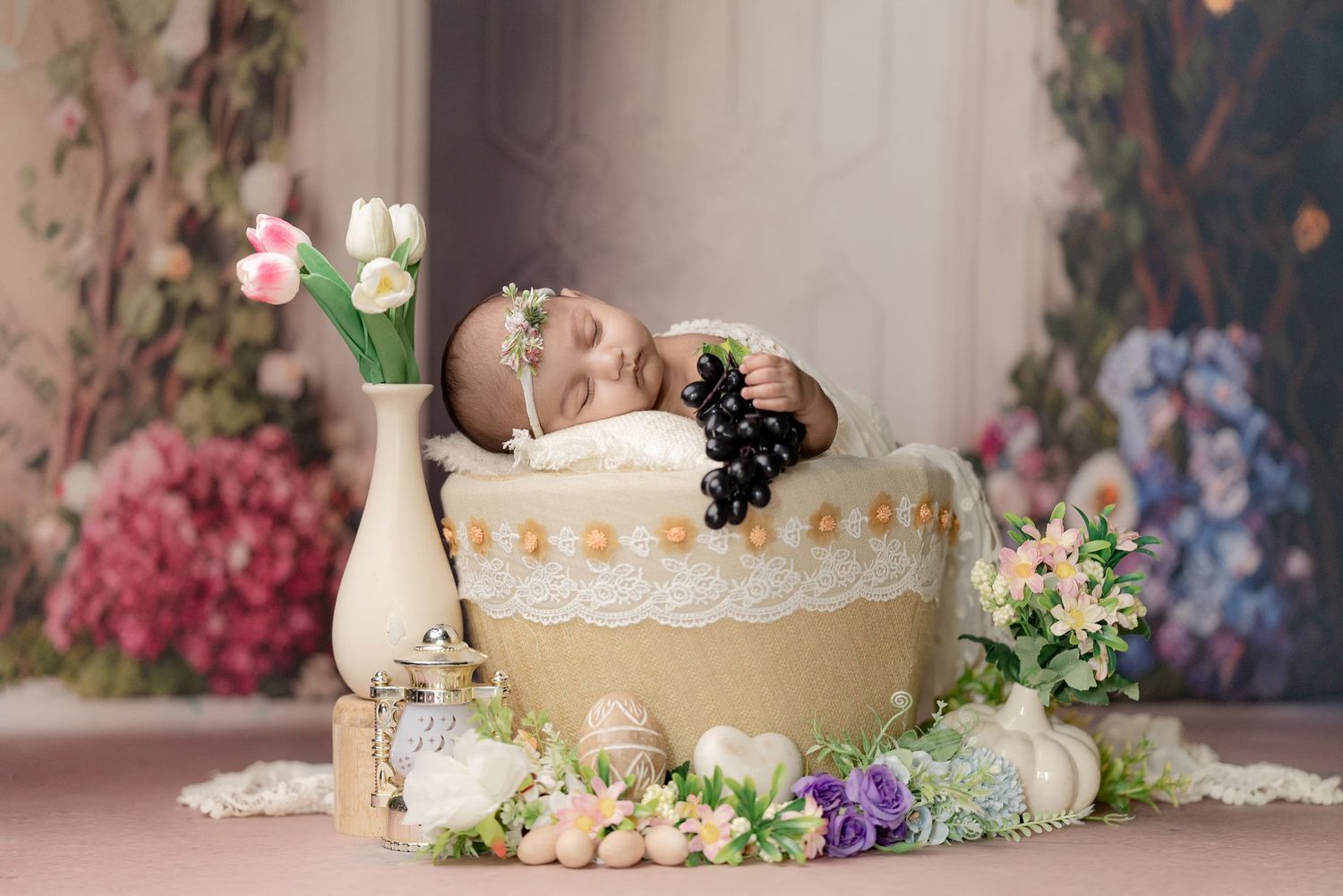 Pastel floral newborn photography studio setup with decorative props and soft lighting.