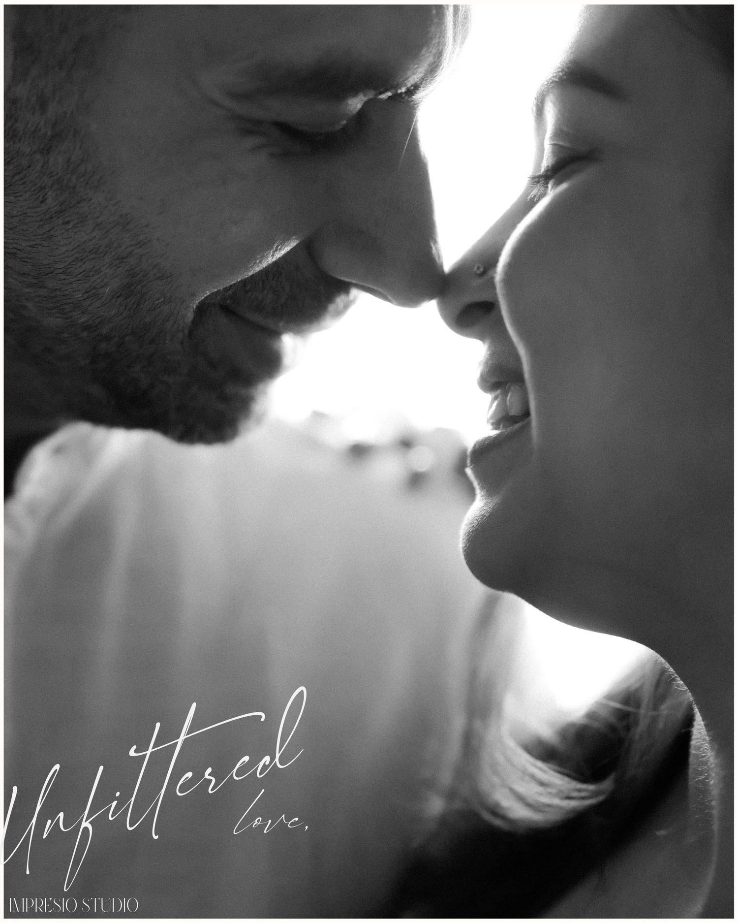 Black and white romantic couple portrait with noses touching, smiling intimately, with Unfiltered Love text overlay.