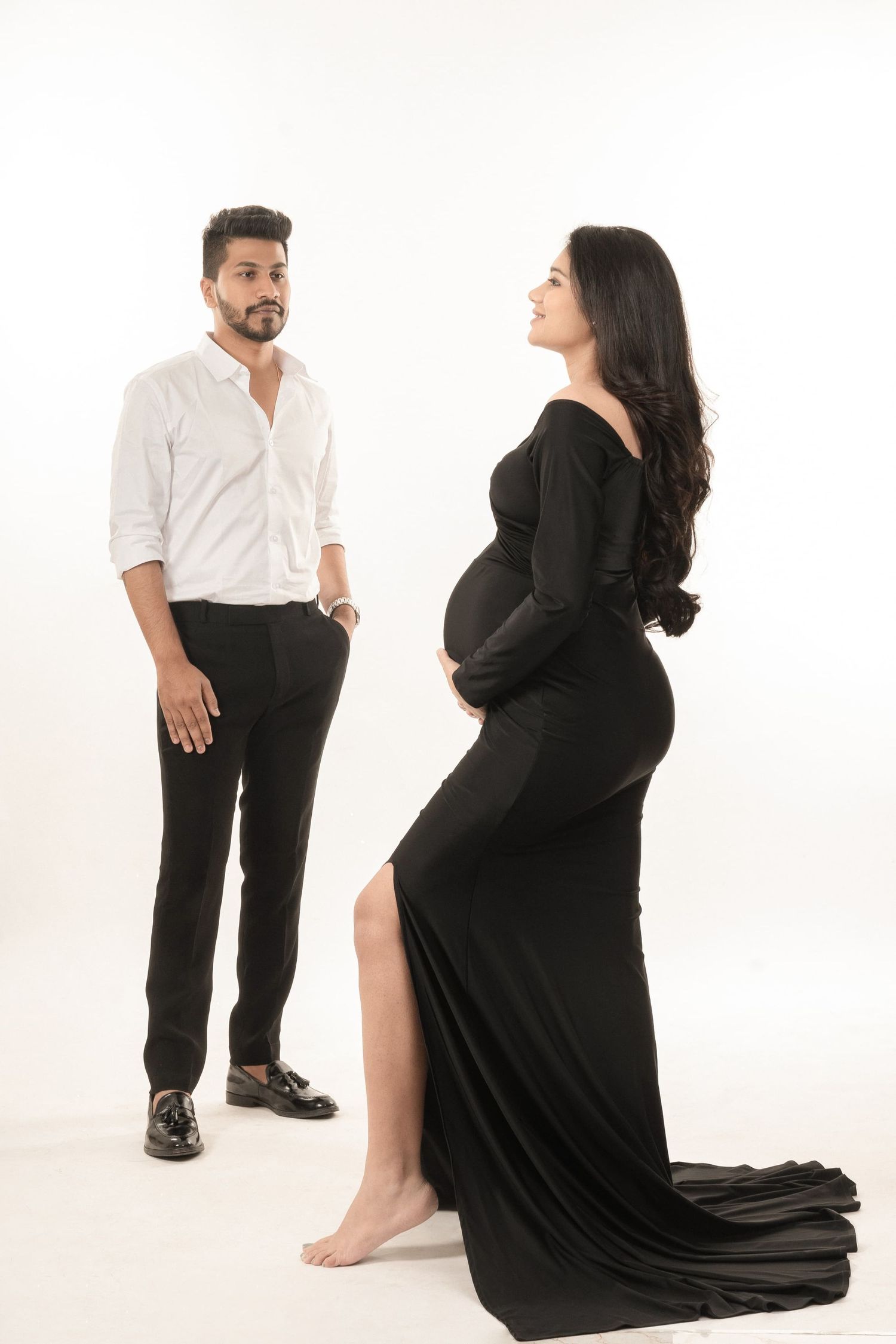 Studio maternity session with couple in contrasting black and white outfits.