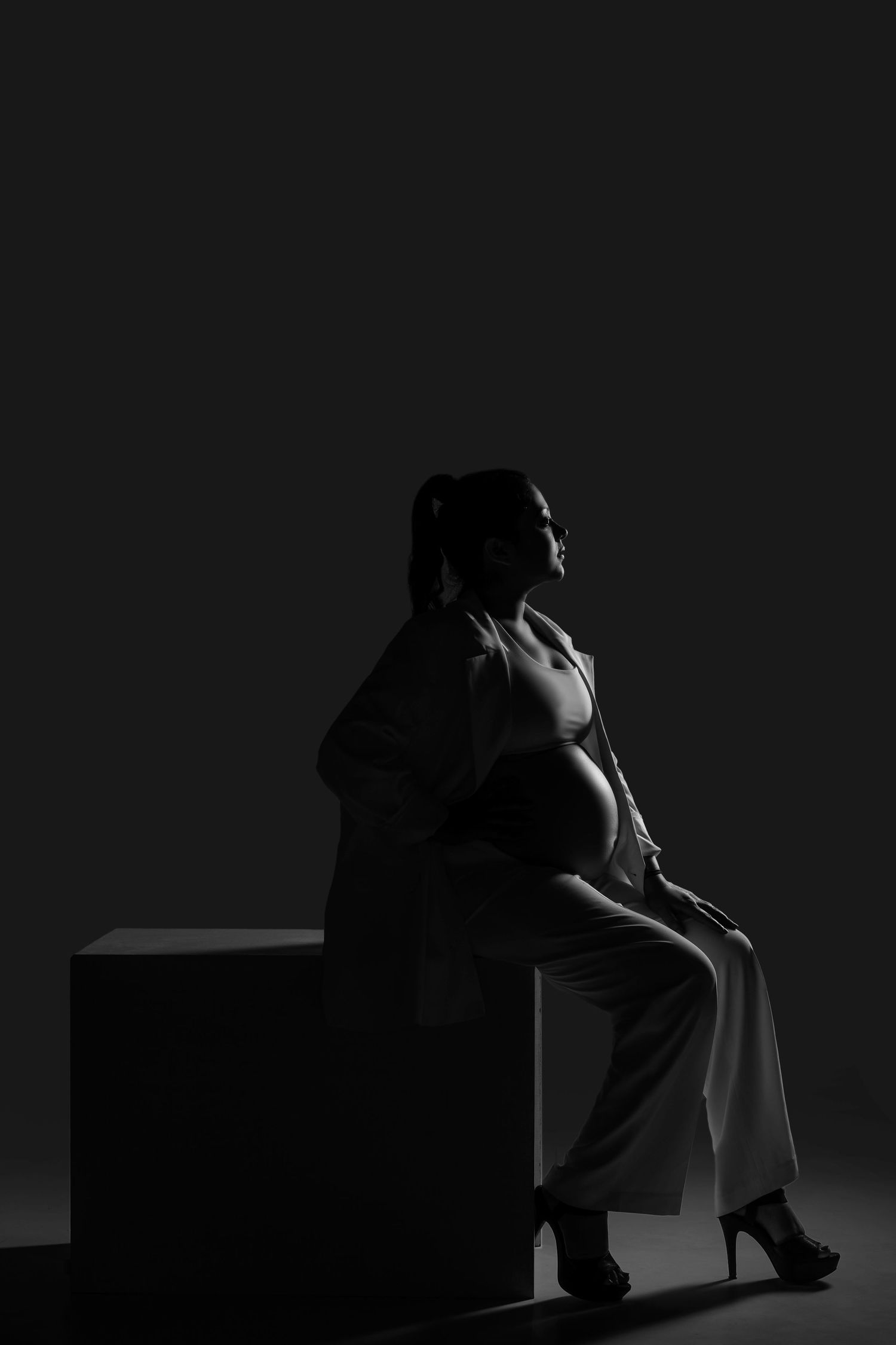 Black and white artistic silhouette portraits of a person's figure in dramatic lighting.